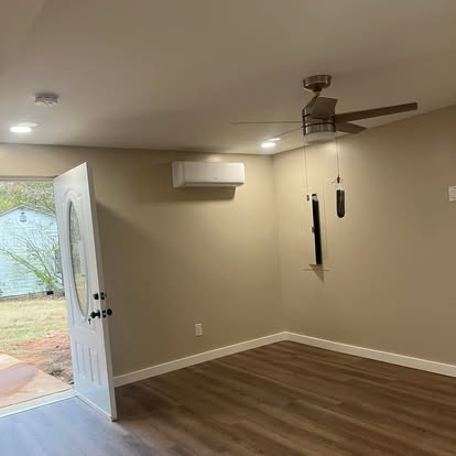 Basement room with open exterior door and ceiling fan