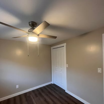 Basement bedroom with ceiling fan and finished walls