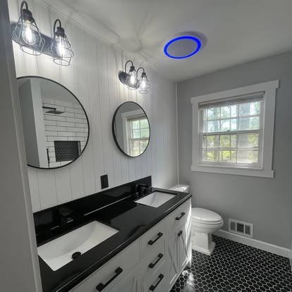 Double vanity bathroom with circular mirrors