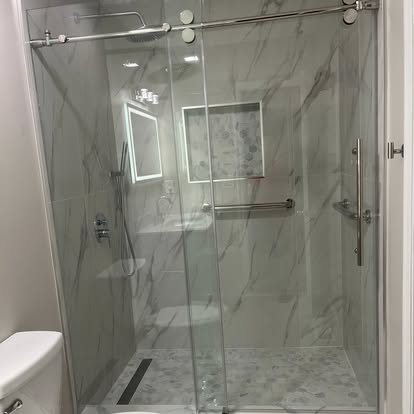 Frameless glass shower with marble-style tile