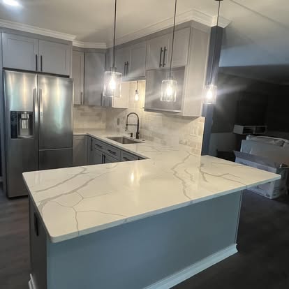 Grey kitchen with quartz peninsula and pendant lights